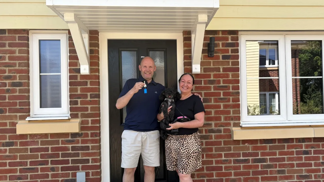 Couple standing in front of home